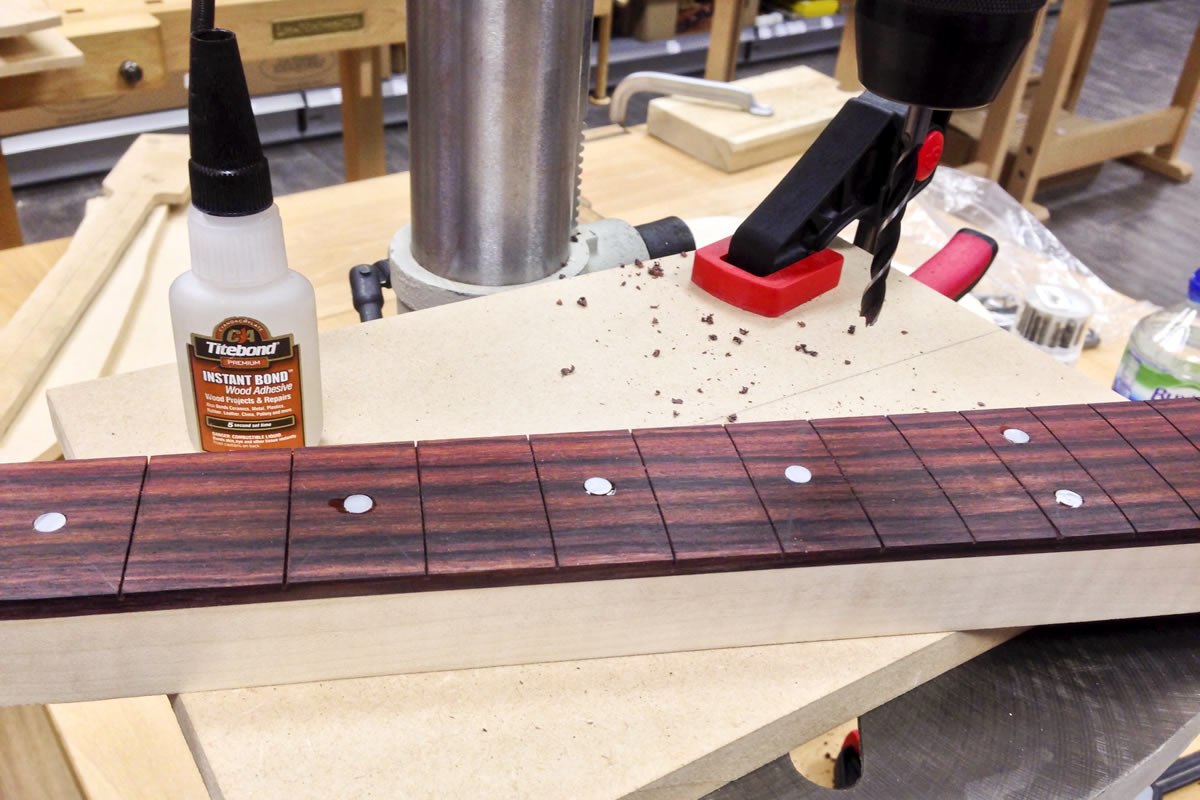 Position markers are glued in and fret slots can be clearly seen