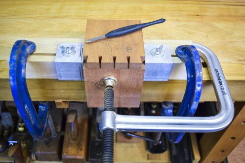 Marked out pin boards on second sections of mahogany, clamped to the workbench.