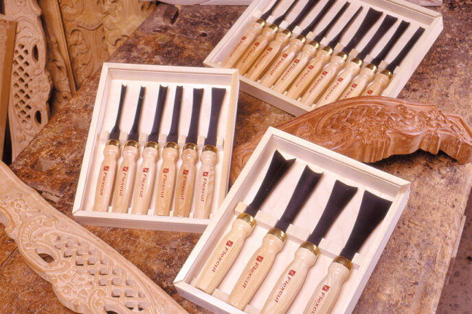 Flexcut mallet carving tools in sets on bench with wood carvings