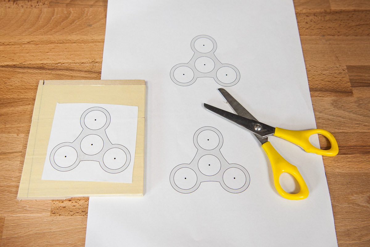 Fidget spinner pattern roughly cut out and glued to timber