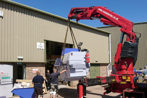 The lathe being craned into the workshop