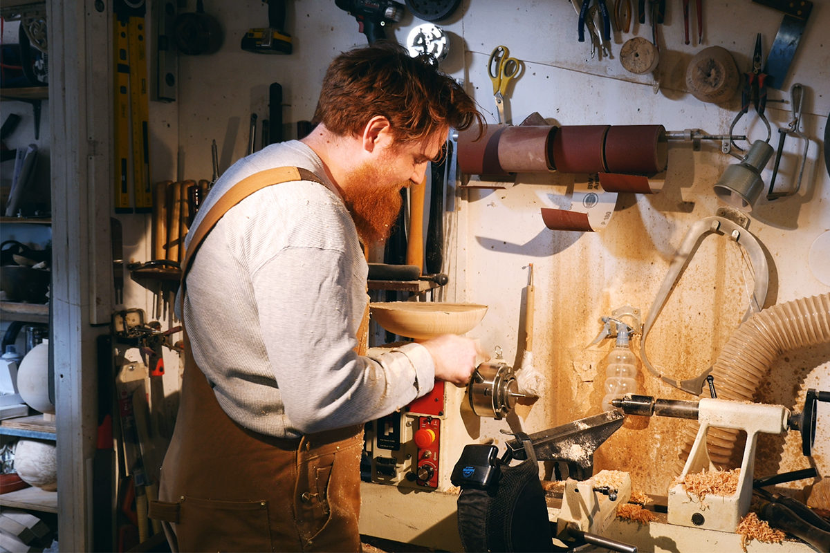sculptor max woodturning on his lathe in the workshop